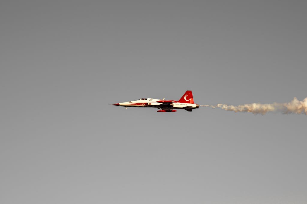 Turkish Air Force jet flying through clear sky with smoke trail, showcasing agility and precision.